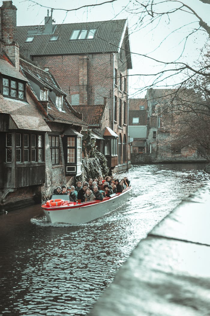 Tourists enjoying a boat ride through a charming European canal, framed by historic architecture.
