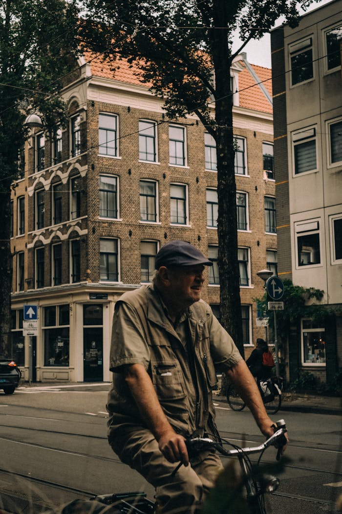 The Art of Drawing Readers In: Your attractive post title goes here Man cycling through historic Amsterdam with classic architecture in view.